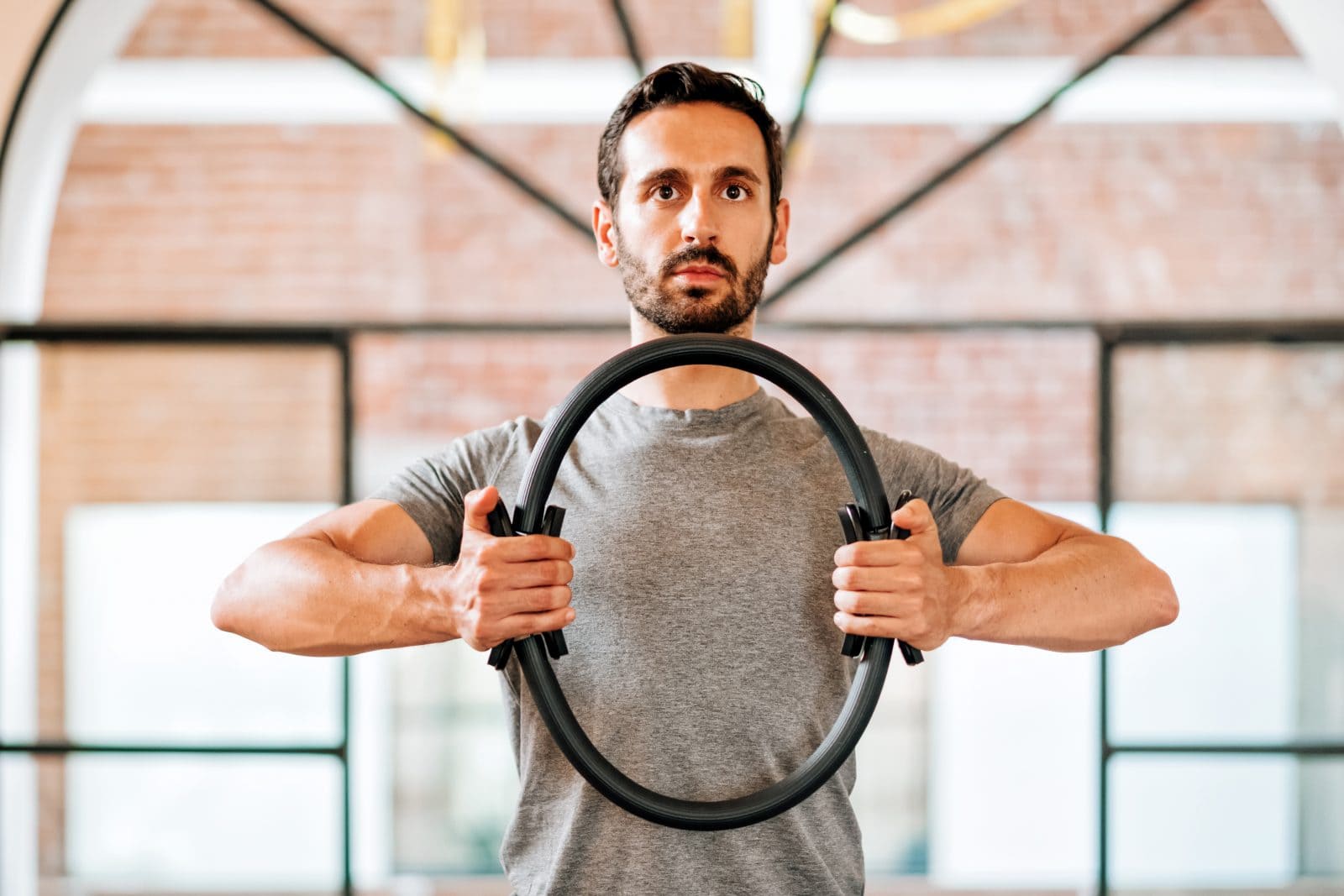 Athletic man using pilates magic circle 1035275