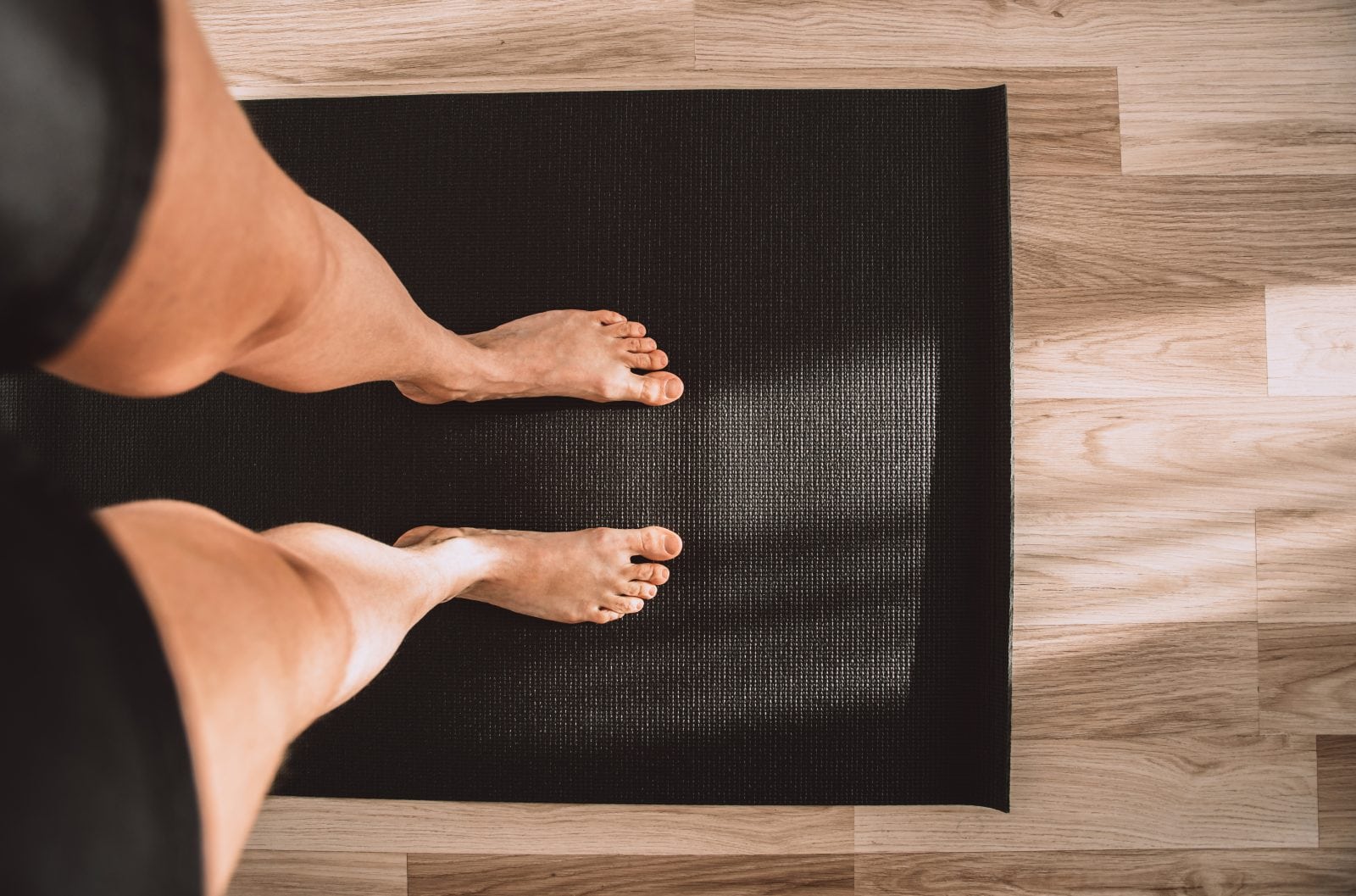 Woman standing on a yoga mat 1161313