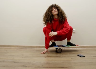 a woman in a red jumpsuit riding a skateboard
